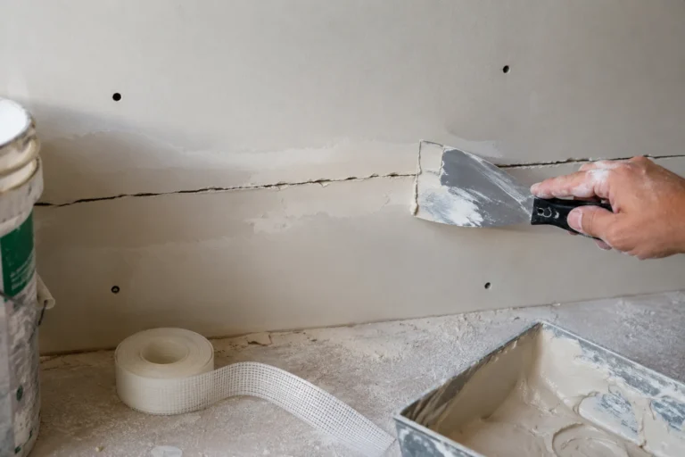 Naprawa pękniętego łączenia płyt GK przy użyciu masy szpachlowej i szerokiej szpachelki